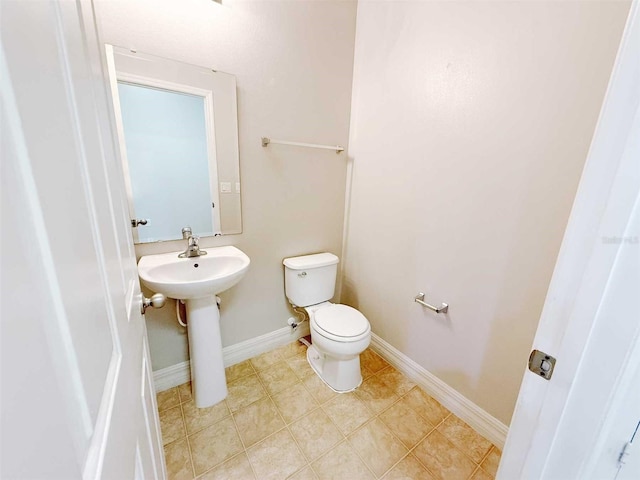 1208 Sawgrass Pointe Dr, Orlando, FL 32824 - half bathroom featuring toilet, baseboards, tile patterned floors, and a sink