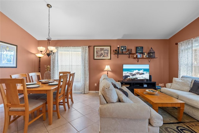 living room featuring light tile patterned flooring, lofted ceiling, and a notable chandelier