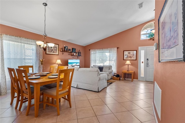 tiled dining area with plenty of natural light, lofted ceiling, and an inviting chandelier