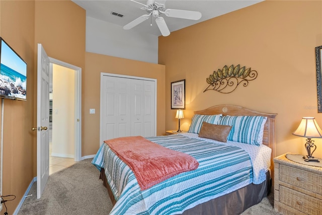 carpeted bedroom featuring a high ceiling, a closet, and ceiling fan