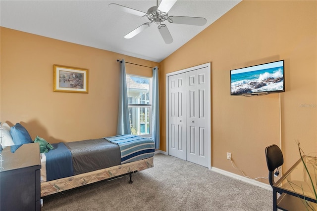 bedroom featuring ceiling fan, a closet, light colored carpet, and lofted ceiling