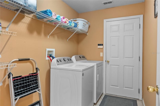 laundry room with washer and clothes dryer and a textured ceiling