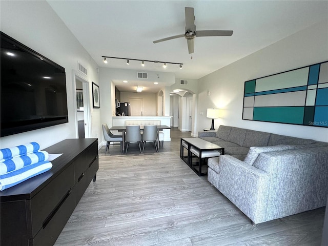 living room featuring ceiling fan and light wood-type flooring