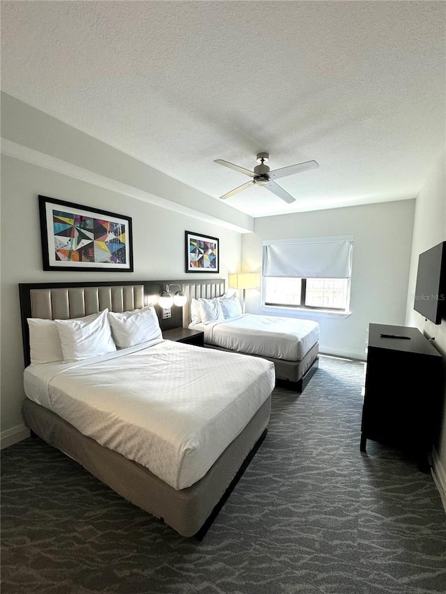 carpeted bedroom with ceiling fan and a textured ceiling