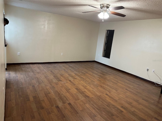 spare room with ceiling fan, dark hardwood / wood-style flooring, and a textured ceiling