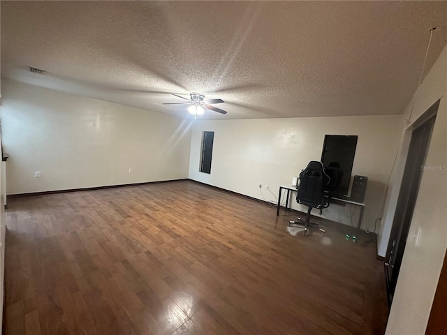 bonus room featuring ceiling fan, dark hardwood / wood-style flooring, a textured ceiling, and electric panel