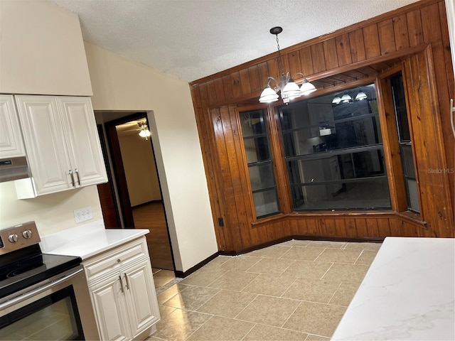 kitchen featuring pendant lighting, electric range, white cabinetry, and lofted ceiling