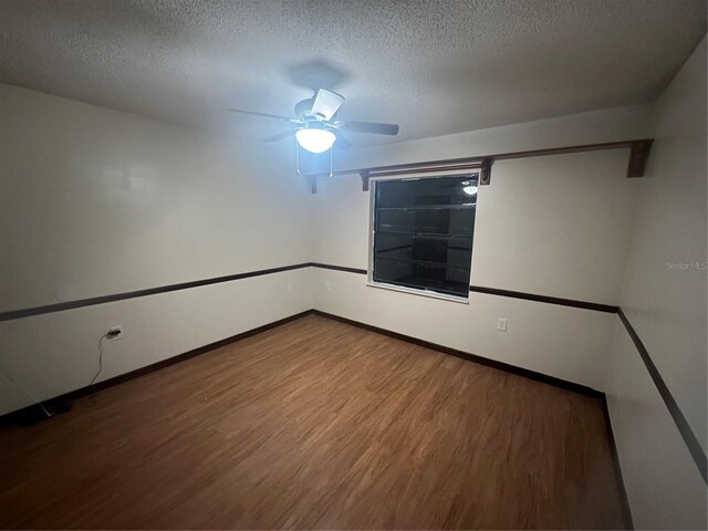 empty room with wood-type flooring, a textured ceiling, and ceiling fan