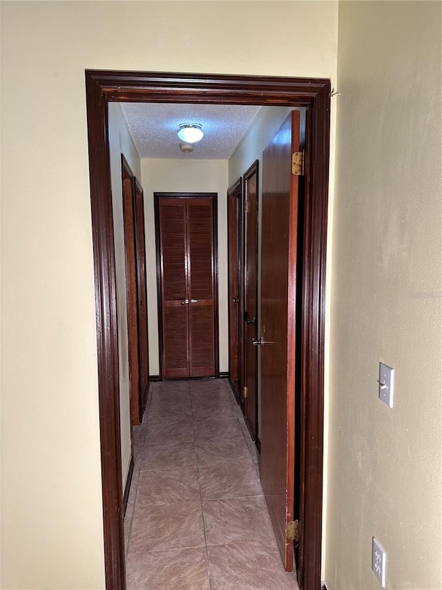 hall featuring a textured ceiling