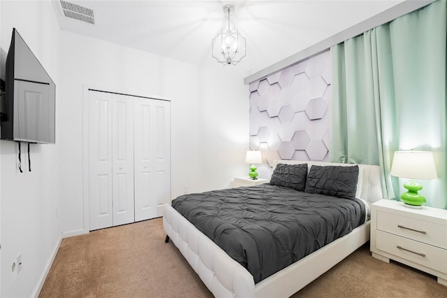 bedroom with a closet, carpet floors, and a notable chandelier