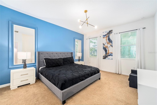 bedroom with light colored carpet and an inviting chandelier