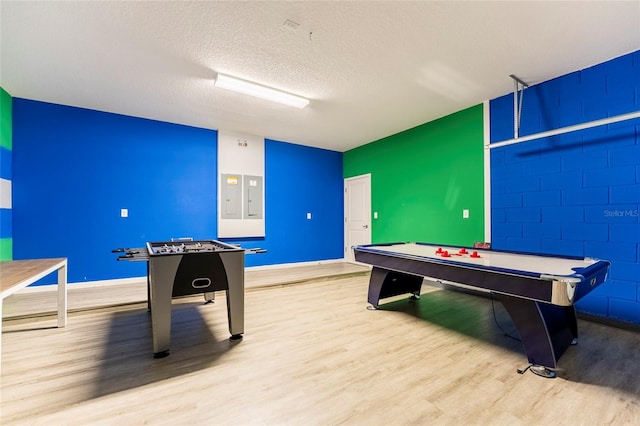 game room featuring a textured ceiling, light wood-type flooring, and pool table