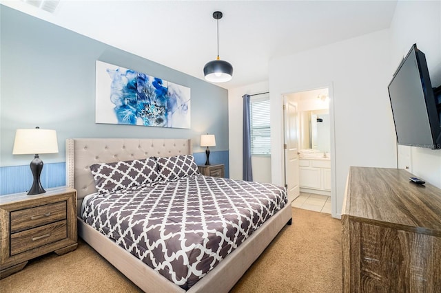 bedroom with light carpet and ensuite bath