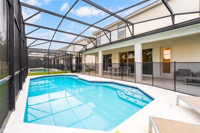 view of swimming pool featuring a lanai and a patio area