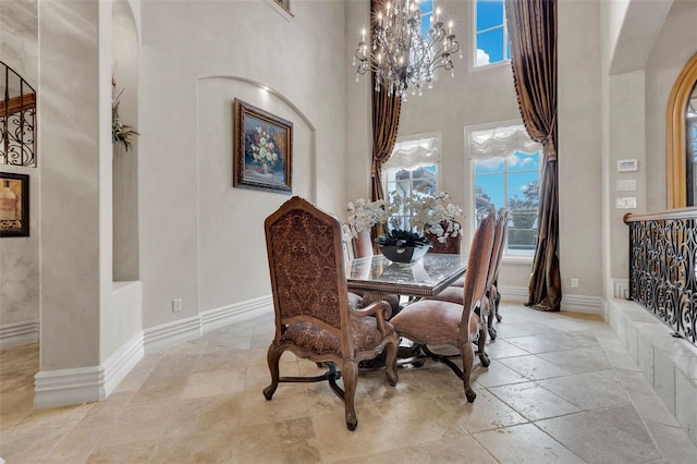 dining area with a high ceiling, a wealth of natural light, and a chandelier