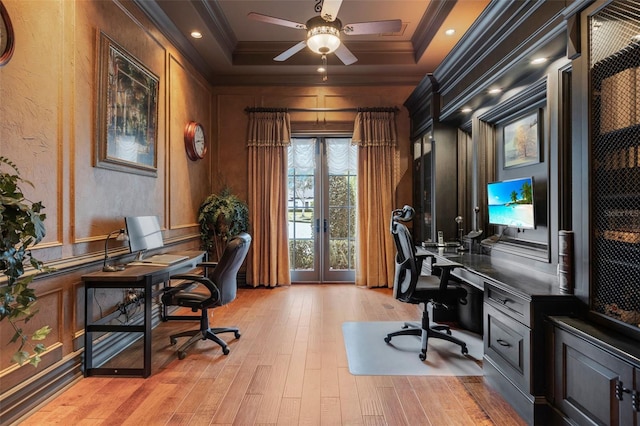 home office with crown molding, french doors, light hardwood / wood-style flooring, and a tray ceiling