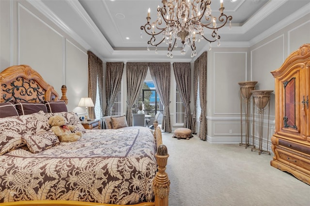 carpeted bedroom with ornamental molding, a tray ceiling, and a chandelier