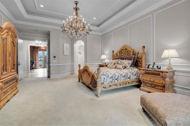 carpeted bedroom featuring a chandelier, a tray ceiling, and ornamental molding