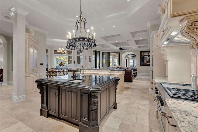 kitchen featuring ceiling fan, hanging light fixtures, a large island with sink, high end range, and custom exhaust hood