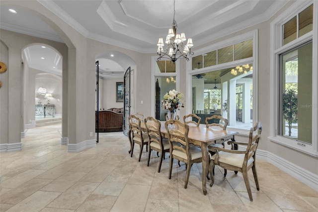 dining space featuring a raised ceiling, crown molding, and a notable chandelier