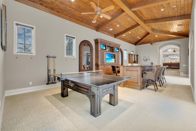 recreation room with vaulted ceiling with beams, ceiling fan, wood ceiling, and light carpet