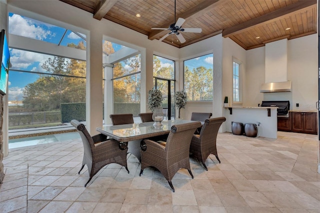 sunroom / solarium with lofted ceiling with beams, ceiling fan, and wood ceiling