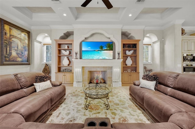 living room featuring a fireplace, ornamental molding, ceiling fan, and coffered ceiling