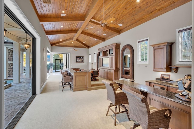 carpeted home office with beamed ceiling, high vaulted ceiling, ceiling fan, and wooden ceiling