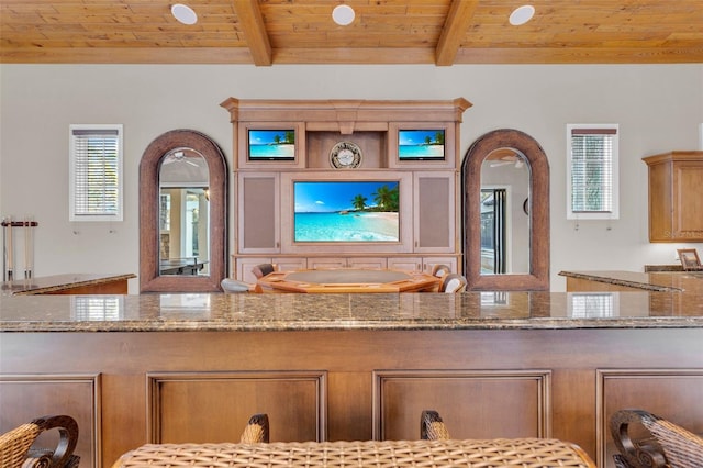 kitchen with beam ceiling, stone countertops, and wooden ceiling