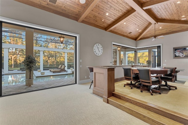 carpeted dining space with vaulted ceiling with beams, ceiling fan, and wood ceiling