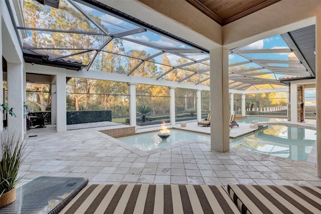 view of pool with a jacuzzi, a patio, and glass enclosure