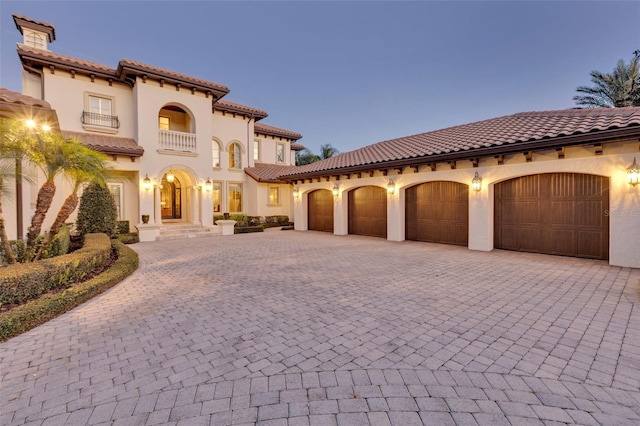 mediterranean / spanish home featuring a balcony and a garage