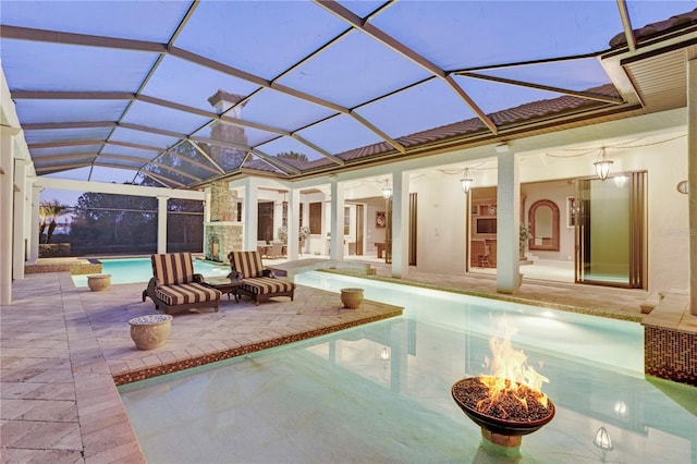 view of pool featuring a patio, glass enclosure, and ceiling fan