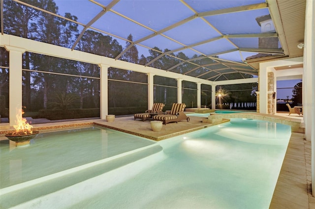 pool at dusk featuring a patio and glass enclosure