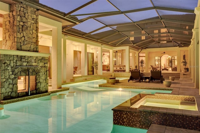 view of swimming pool with an in ground hot tub, a patio, glass enclosure, and ceiling fan