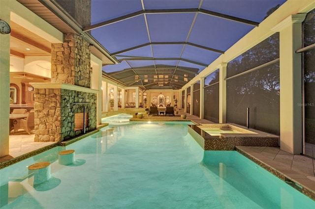 view of pool with a lanai, a patio area, and an in ground hot tub