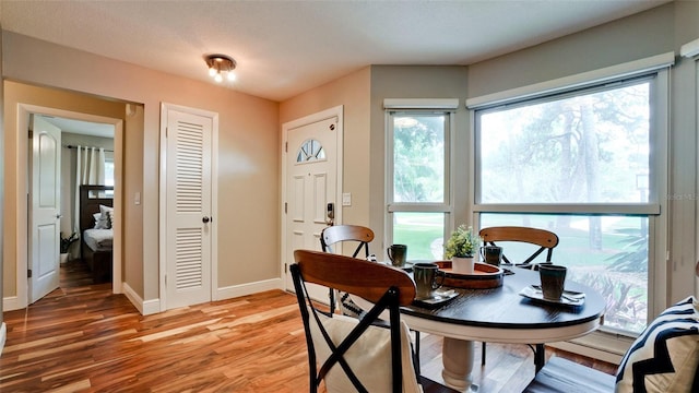 dining area featuring wood-type flooring and a textured ceiling