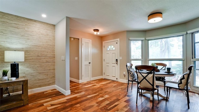 dining area with wood-type flooring and tile walls