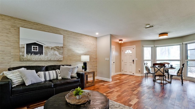 living room with hardwood / wood-style flooring and a textured ceiling