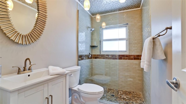 bathroom featuring toilet, a tile shower, and vanity