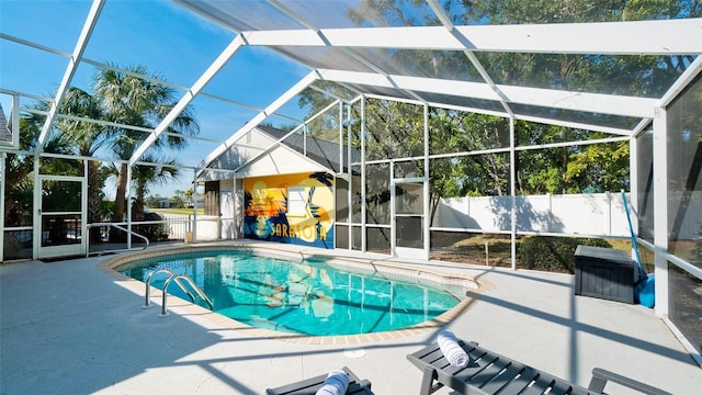 view of pool with a patio area and glass enclosure