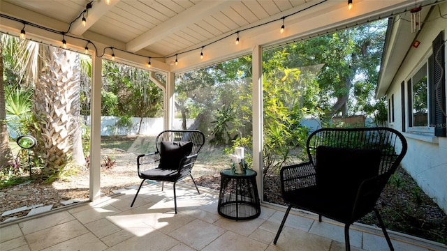 unfurnished sunroom with beam ceiling and wood ceiling