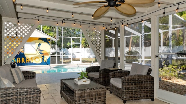 sunroom featuring ceiling fan, beam ceiling, and a wealth of natural light