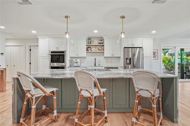 kitchen featuring white cabinets, appliances with stainless steel finishes, and a spacious island