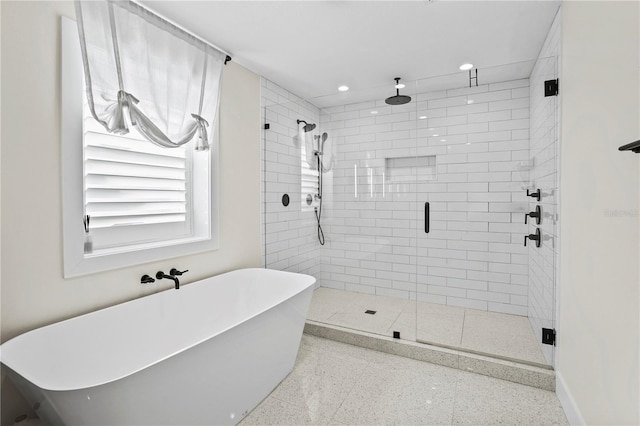 bathroom featuring shower with separate bathtub