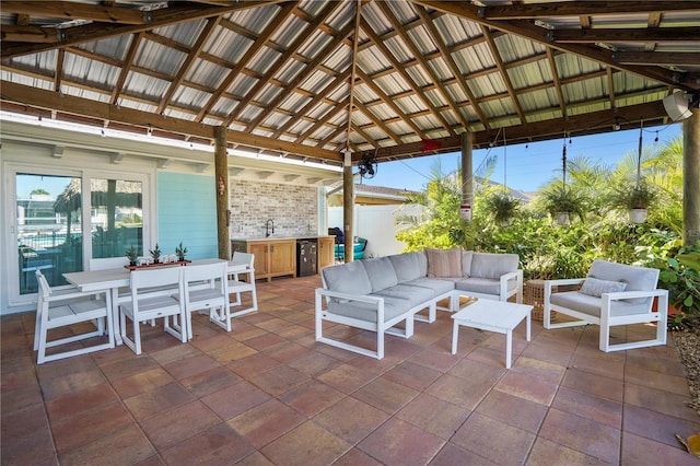 view of patio / terrace with an outdoor hangout area, a gazebo, exterior kitchen, and sink