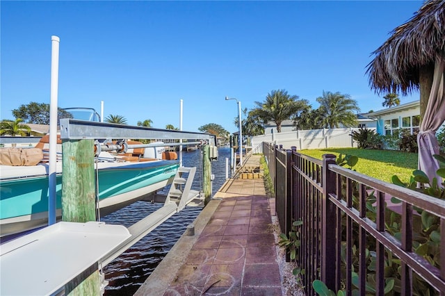 dock area with a water view and a yard