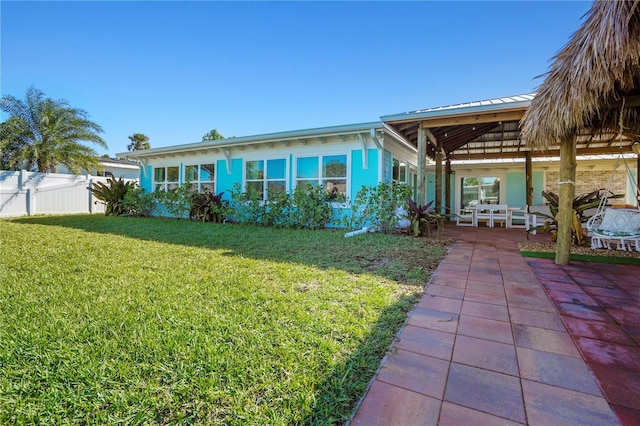 rear view of house featuring a patio area and a lawn