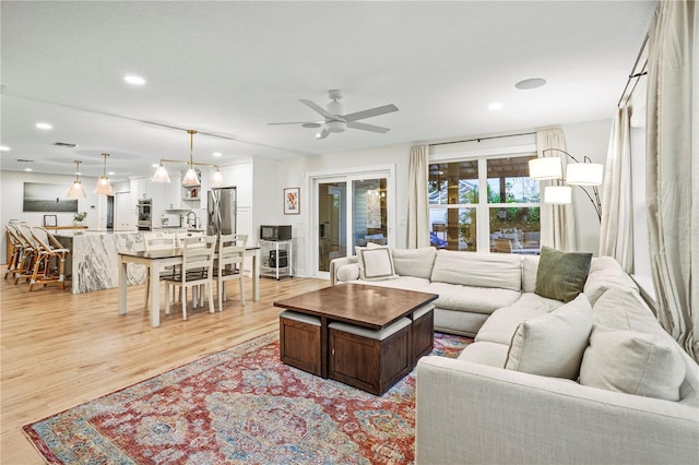 living room featuring ceiling fan and light hardwood / wood-style flooring