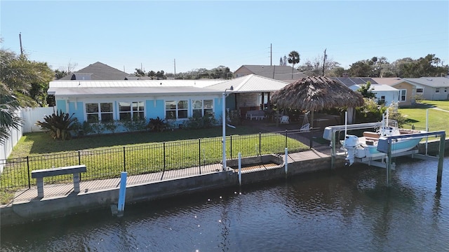 view of dock with a water view, a gazebo, and a lawn